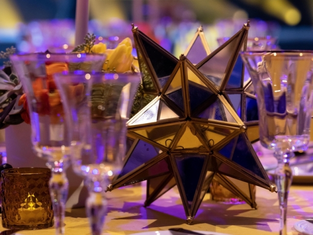 Close up of table centerpiece with modern gold star decor.