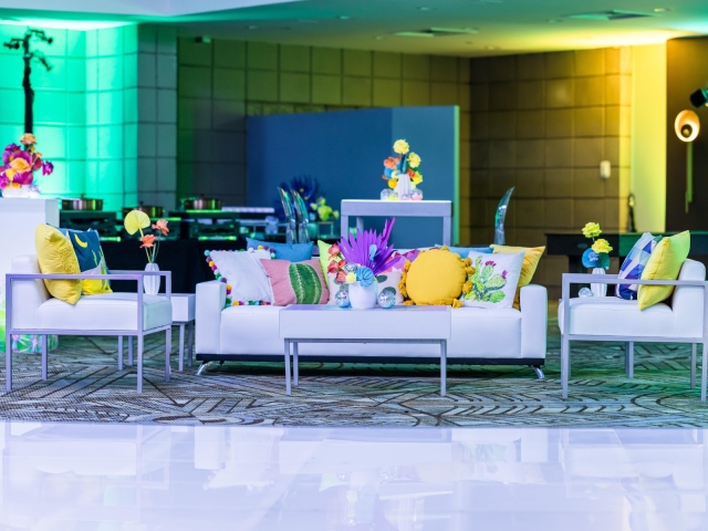 Lounge area with white couches and sofa chairs with accent pillows.