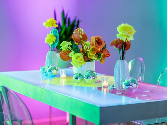 Bright floral centerpiece on table with disco balls.