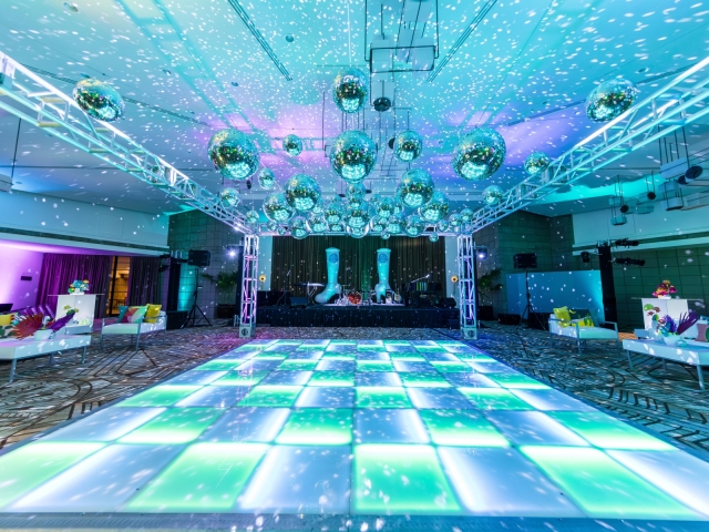 Vibrant dance floor with hanging disco balls.