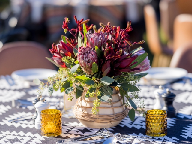 Close up of floral centerpiece with a variety of flowers and candles.