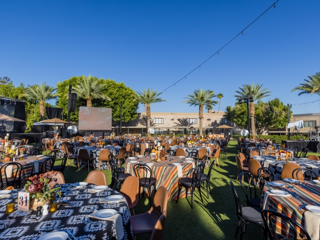 Full view of the event space with close to 40 round tables with different patterned table clothes.