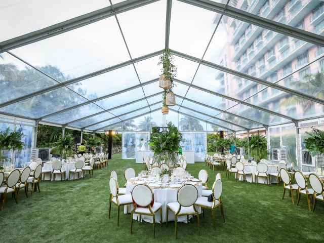 Outdoor incentive dinner with gold and white tables, foilage centerpieces in pavilion.