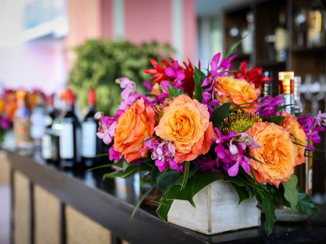 Welcome reception bar with bright floral arrangement.