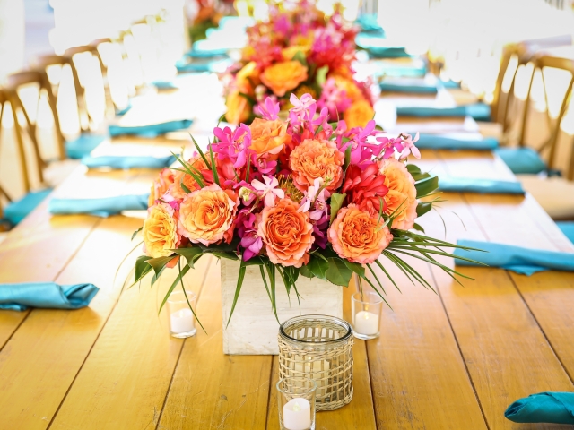 Up close of the table setting with bright  floral arrangements.