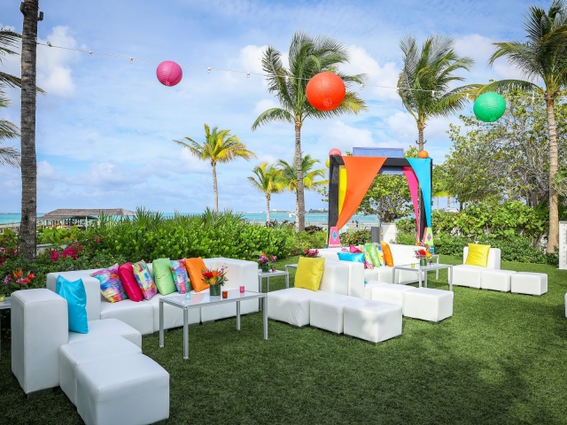 Junkanoo lounge area with white couches and vibrant pillows