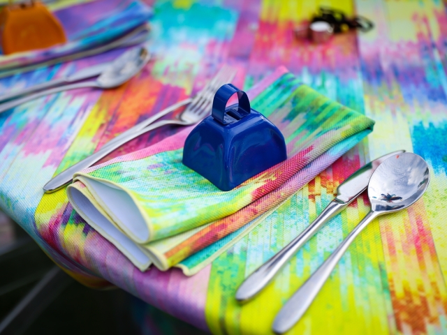 Junkanoo table setting with bright tie dye table cloth.