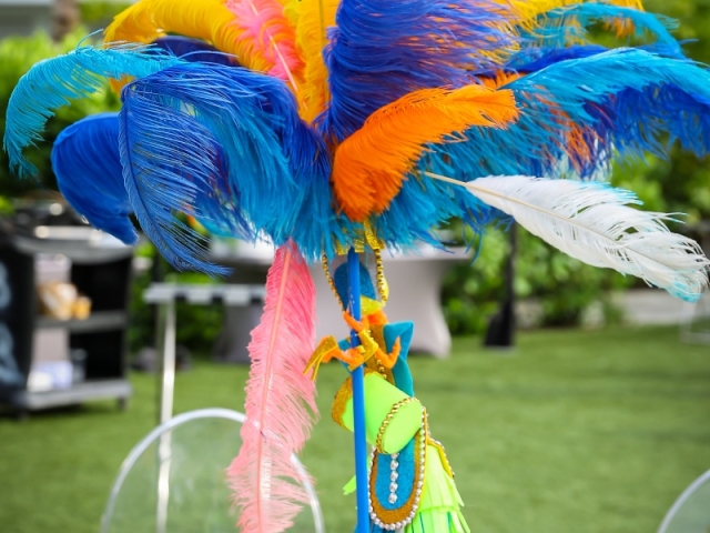 Junkanoo colorful feathered centerpiece on vibrant table cloth.