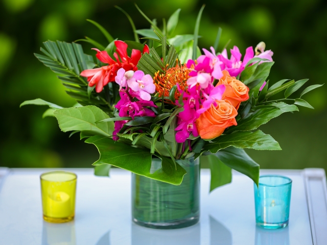 Junkanoo floral arrangements with bright flowers and candles.