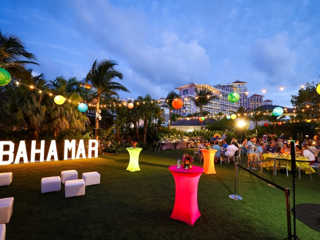 A view of a Junkanoo event at night with LED Baha Mar sign.