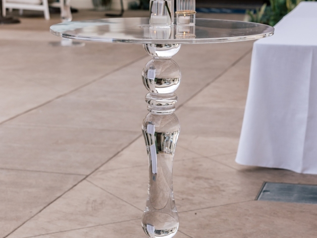 Clear glass high top table with white orchids.