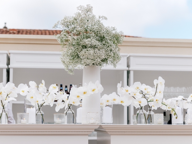 Beautiful white floral display with large white baby's breath arrangements in white vase.