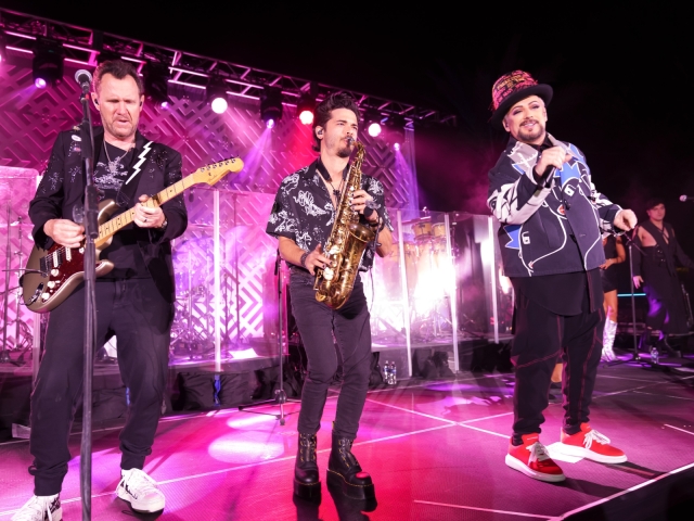 Boy George performing with band at dessert reception.