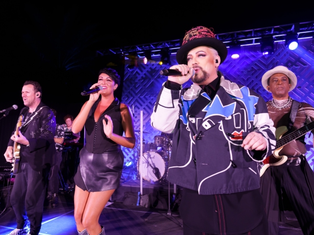 Boy George performing with band at dessert reception.