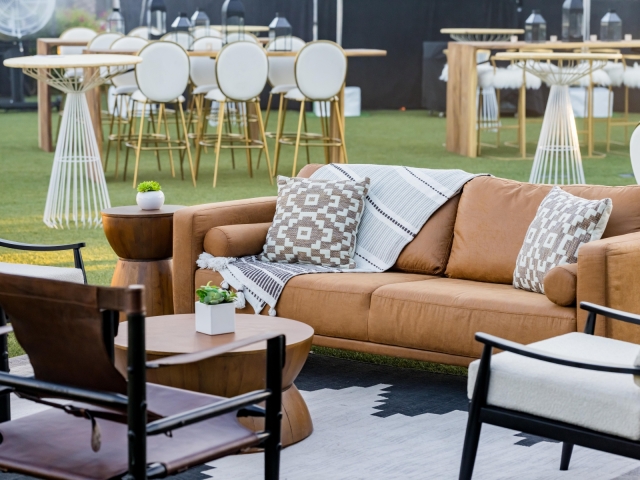 Lounge area at dessert reception with orange cushions and brown and white patterned pillows.