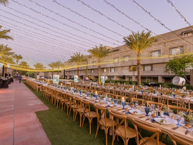 King table with hanging lights stretched across the event space.