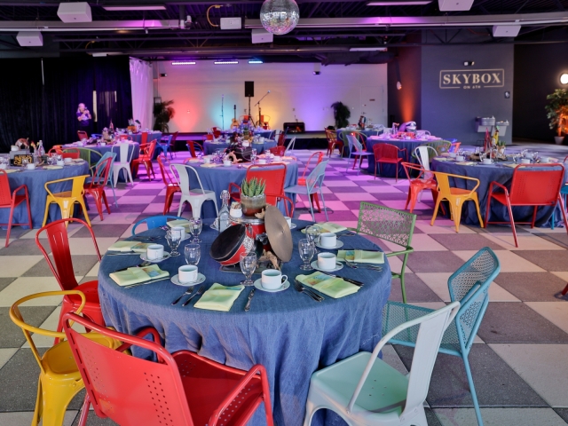 Tables with different style chairs and blue tablecloth.