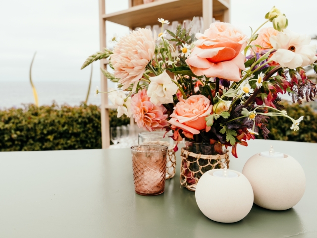 Table centerpiece with coral floral arrangement.