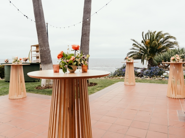 4 high top tables with floral centerpieces.