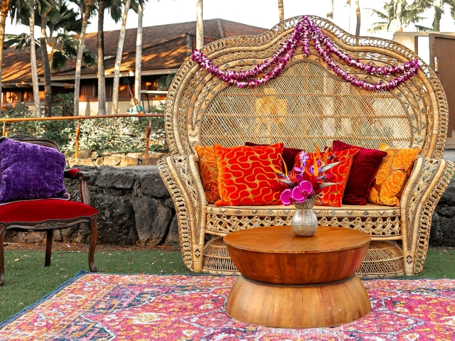 Large wicker chair with vibrant pillows at a presidents club event.