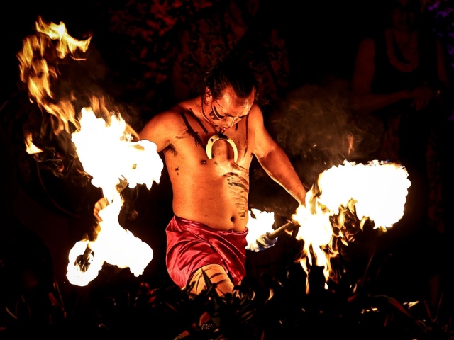 Man playing with fire on stage at final night party.