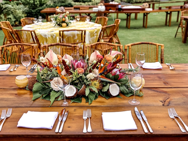 Beautiful floral centerpiece on wooden table with a variety of Hawaiian flowers.