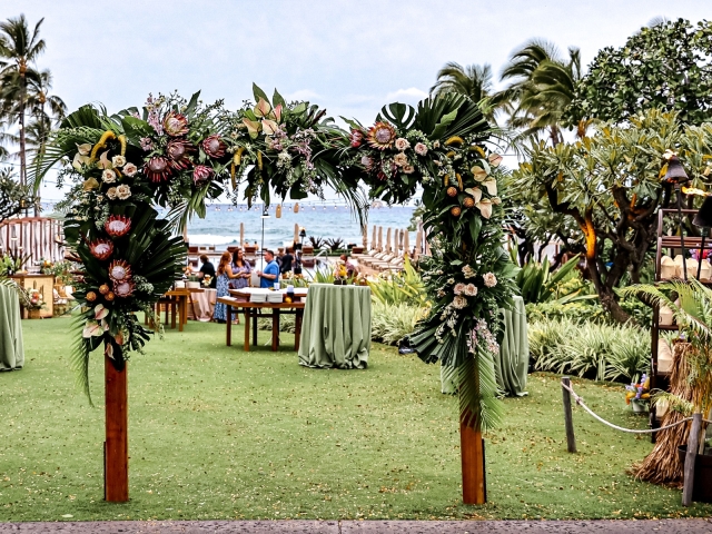 A floral archway at an outdoor venue overlooking the ocean for Presidents Club in Hawaii.