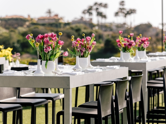 Close up of grey rectangular table with pink tulips.