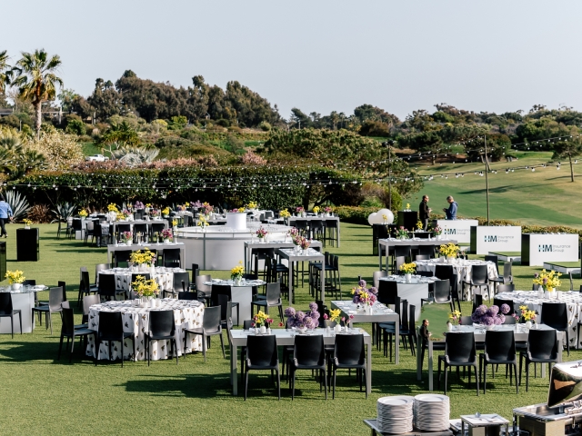 Full view of event space with rectangular and round tables.