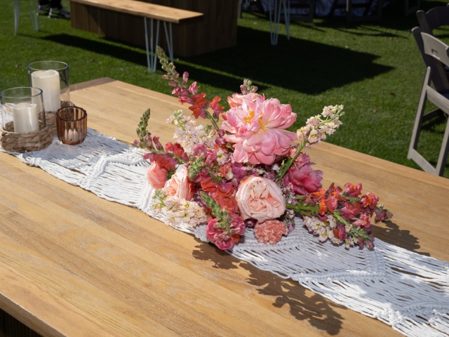 Floral arrangement on table with red and pink flowers.