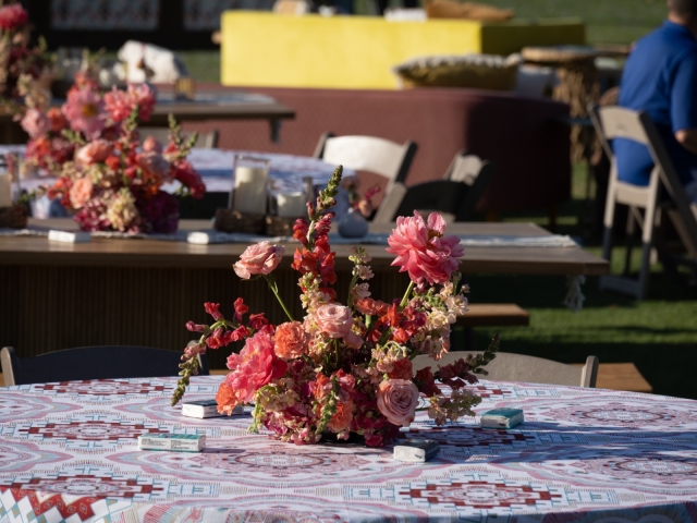 Smaller centerpiece on a round table with bright flowers.