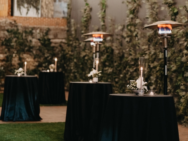 High top tables at elegant wedding with black table clothes