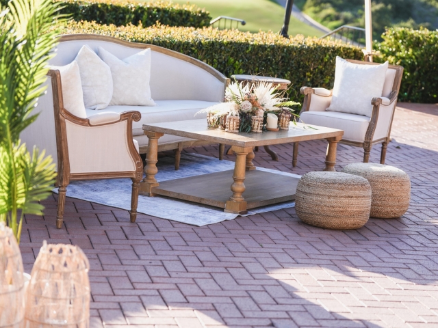 Lounge area with cream couch and chairs with brown table and round bean chairs.