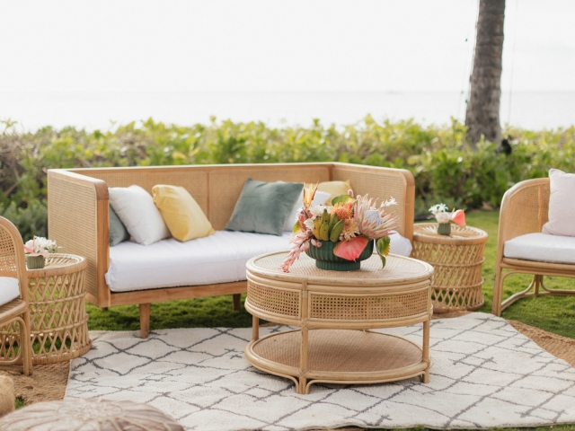 Lounge area with wicker-like couch, chairs, and ottoman table.