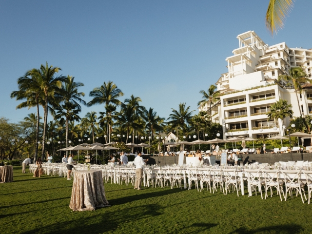 A full view of an outdoor venue for influencer event with long tables, white chairs and sporadic high top tables.