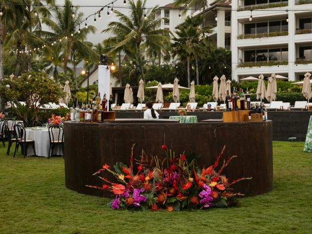 A view of the bar with a large floral centerpiece sitting on the ground beside it.